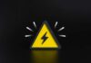 Wartime Powers Hit U.S. Electric Grid A yellow triangular warning sign with a lightning bolt on a black background