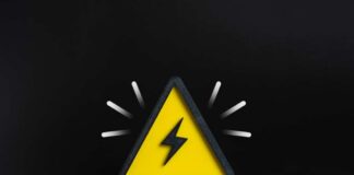 A yellow triangular warning sign with a lightning bolt on a black background