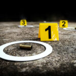 Deadly Chaos As Bullets Fly Crime scene with evidence markers and a bullet casing on the ground