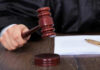 Bannon Twist: Judge Blocks Quiet Erase Judges hand holding gavel next to documents.