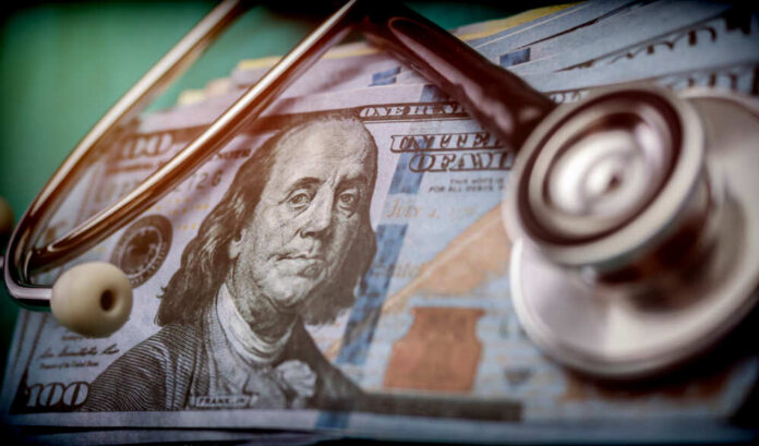 Phonendoscope,On,American,Tickets,,Concept,Of,Sanitary,Copayment A stethoscope resting on a stack of hundred-dollar bills