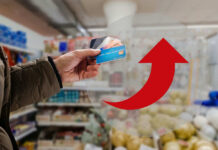 Credit Card Time Bomb Ticks Louder Hand holding credit cards with red upward arrow