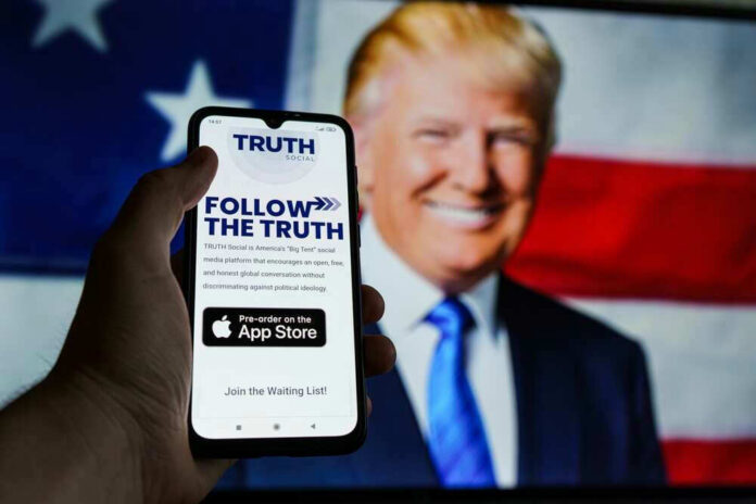 Smartphone displaying Truth Social app, Donald Trump background.