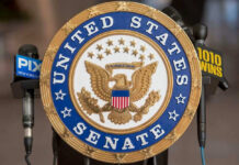 One Senator Flips — Everything Changes United States Senate seal with microphones in front.