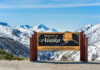 Alaska welcome sign with snowy mountains in background