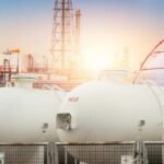 Trump Slams Big Oil’s War Jackpot Gas storage tanks in an industrial facility during sunrise