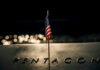 Pentagon Burned Through The Arsenal? American flag above engraved Pentagon sign at night