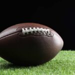 VIDEO: Sideline Collapse, Death Stuns College Football Football player kneeling on the field with a helmet beside them