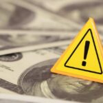 Oil, Ships, Crypto — All On Notice?! A yellow warning sign on a background of dollar bills