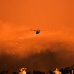 Hero Pilots Downed — Questions Ignite Helicopter fighting massive forest fire with water bucket.