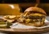 Fast-Food Shake-Up: Who Fell Hardest? A double cheeseburger with melted cheese and pickles served with potato wedges