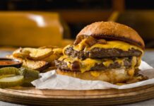 Fast-Food Shake-Up: Who Fell Hardest? A double cheeseburger with melted cheese and pickles served with potato wedges