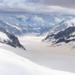 Blue glacier ice with crevasses and rocky surface