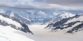 Blue glacier ice with crevasses and rocky surface