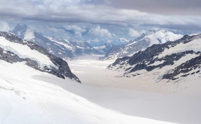 Aletsch,Glacier,,The,Bigger,Glacier,In,Swiss,Alps,From,Top Blue glacier ice with crevasses and rocky surface