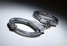 Close-up of metallic handcuffs on a light surface