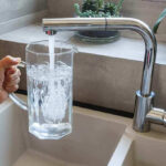 Abortion Pills Found in Tap Water? Hand filling pitcher with water from faucet.
