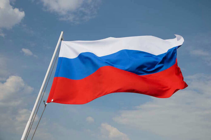 1902803902 Russian flag waving against a cloudy sky.