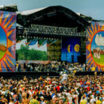 Beach Festival CHAOS: 19 Injured in Mass Panic A large crowd at an outdoor music festival with a vibrant stage