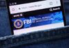 FBI Files SEIZED – What Got Hit? Mobile phone displaying the FBI website in a denim pocket