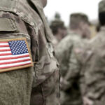 U.S. Military Complex Disguised As Monument? U.S. soldiers in camouflage uniforms with American flag patch.