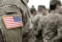 U.S. Military Complex Disguised As Monument? U.S. soldiers in camouflage uniforms with American flag patch.