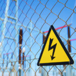 High voltage warning sign on a chain-link fence at an electrical substation