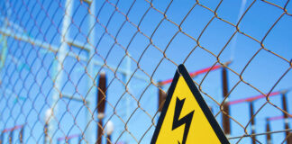 High voltage warning sign on a chain-link fence at an electrical substation