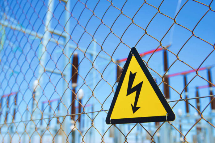 Electrical,Hazard,Sign,Placed,On,A,Metal,Fence. High voltage warning sign on a chain-link fence at an electrical substation