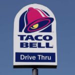 Taco Bell drive-thru sign against a clear blue sky