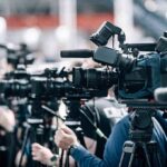 Trump Boost Tips South Carolina Showdown Broadcast cameras on tripods at a press event