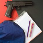 VIDEO: Shooting Rampage At High School Handgun beside school supplies and a blue backpack