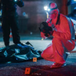 GUILTY: Fake Badge Murders Forensic investigator examines crime scene at night.