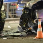 Horrific Crash: Five Dead, Dozens Injured Car crash scene with two damaged vehicles and an orange traffic cone