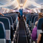 Airline Rips Out Coach To Cash In Airplane interior with passengers seated mid-flight.