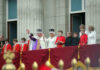 People in royal attire on a palace balcony.