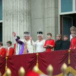 Security Meltdown Hits Royals People in royal attire on a palace balcony.