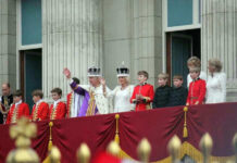 People in royal attire on a palace balcony.
