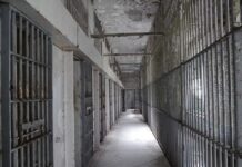 Last-Minute Death Row Bombshell Empty prison corridor with barred cells on either side
