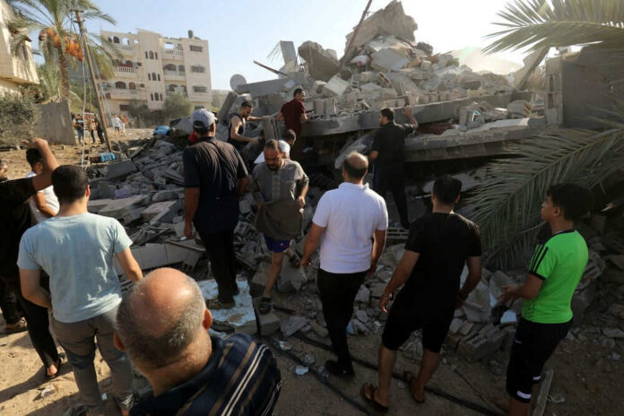 shutterstock_2374656285 People search through rubble of a collapsed building