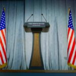 Podium between two American flags on a stage