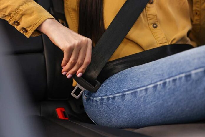 Woman,Fastening,Safety,Seat,Belt,Inside,Modern,Car,,Closeup Person fastening a seat belt in a car