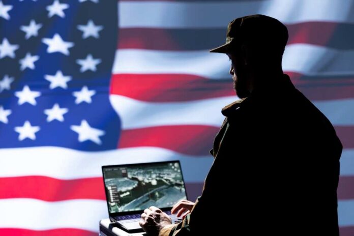 Silhouette of a person using a laptop before a large US flag