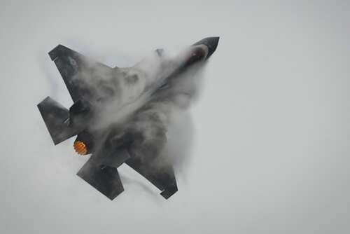 Thailand,Bangkok,-07,March:,Us,Air,Force,F-35a,Fighter,Jet Fighter jet performing an aerial maneuver with smoke trailing behind