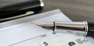 Close-up of a fountain pen poised over a blank check