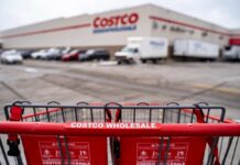 These Popular Costco Deals Axed — No Warning Shopping cart in front of a Costco Wholesale store