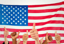 Cheaper Cars Get Trump Okay! Thumbs up in front of American flag.