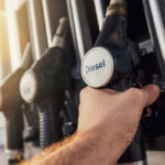 War Explodes Diesel To THIS New High A hand holding a diesel fuel nozzle at a gas station