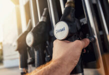 War Explodes Diesel To THIS New High A hand holding a diesel fuel nozzle at a gas station
