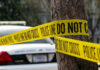 Family Day Turns War Zone Police tape surrounding a tree and police car.